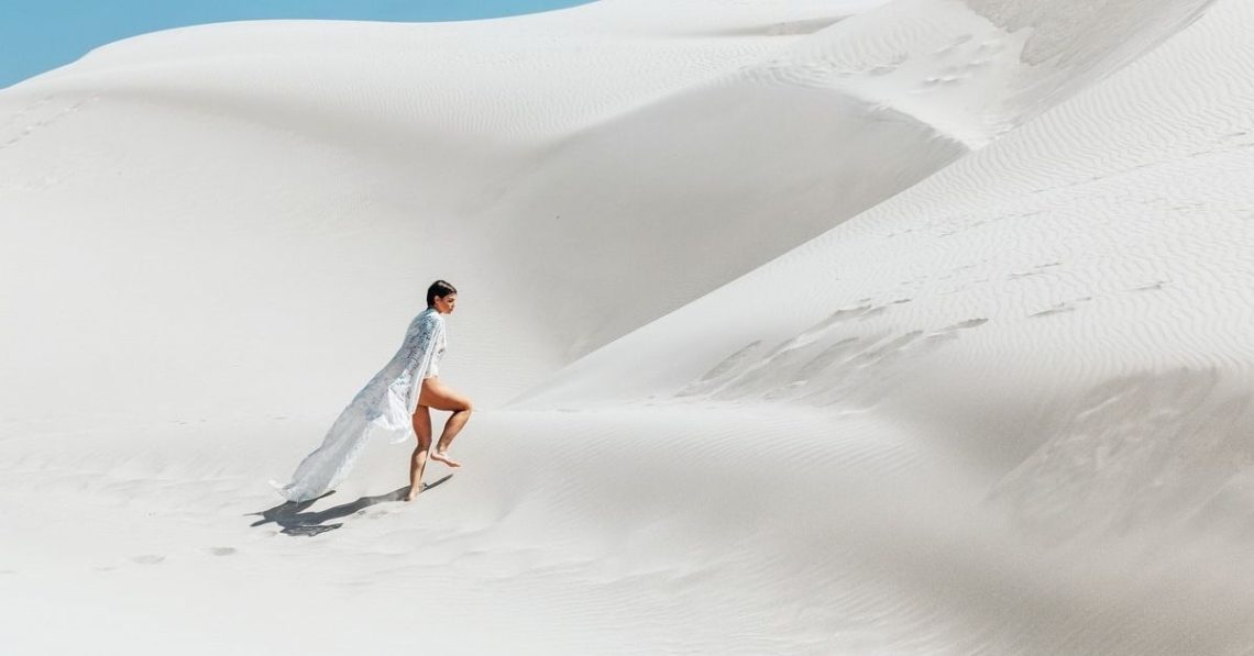 person walking in the sand